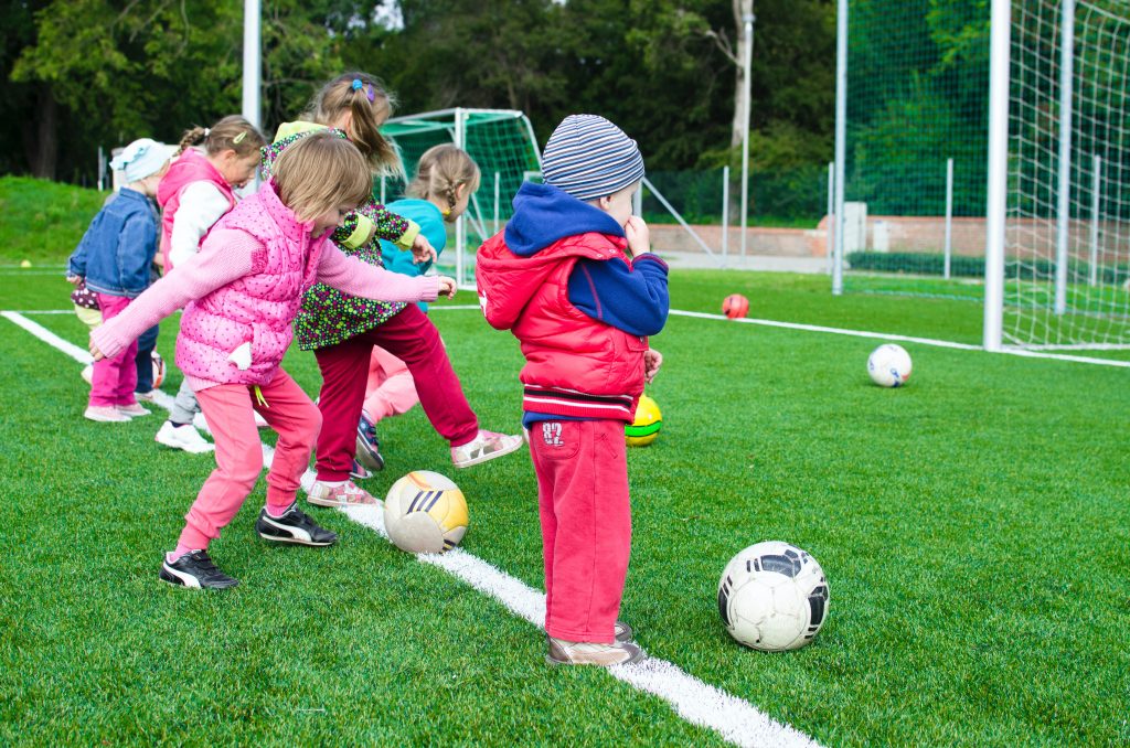 Kinder beim Fußballspielen während eines Kidnergartenausflugs.